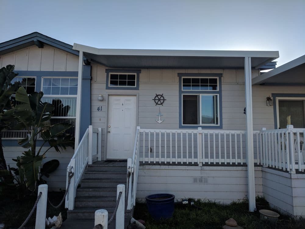 Front view of a coastal home featuring decorative star and anchor symbols on the porch.