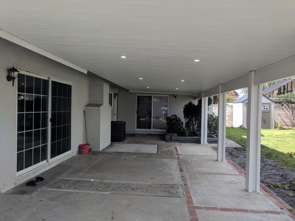 Spacious porch with recessed lighting, gray walls, and access to backyard.